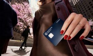 A person holding a Chase Sapphire Reserve card outdoors in a city, highlighting the luxury lifestyle associated with premium credit cards.