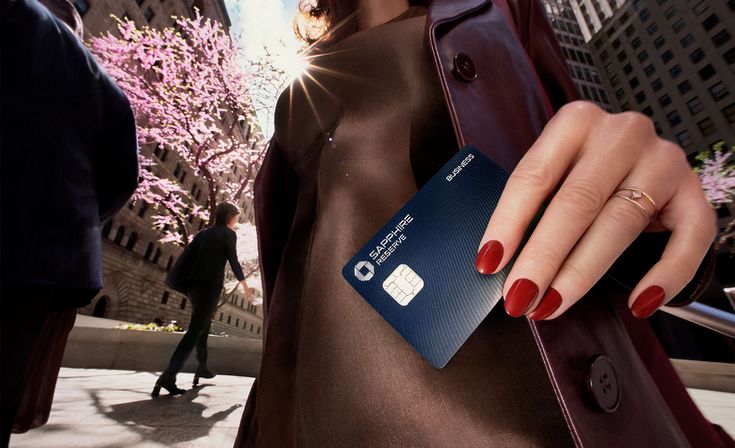 A person holding a Chase Sapphire Reserve card outdoors in a city, highlighting the luxury lifestyle associated with premium credit cards.