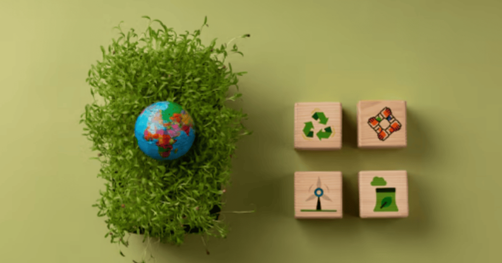 Globe surrounded by green plants and wooden blocks with sustainability icons, representing environmental information and eco-friendly initiatives.